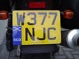 Motorcycle plate with an unofficial, but permitted,<br>SCO band. SCO = Scotland. W = registered between<br>March and August 2000. JC = Bangor