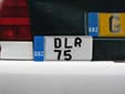 Dealer plate with an unofficial, yet tolerated, plate style and<br>color scheme. Official dealer plates have white characters<br>on a light blue background. DLR = dealer